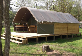 Tenda safari Kibo al campeggio Ushuaïa Villages Le Viaduc, Francia, con terrazza in legno immersa nel verde.