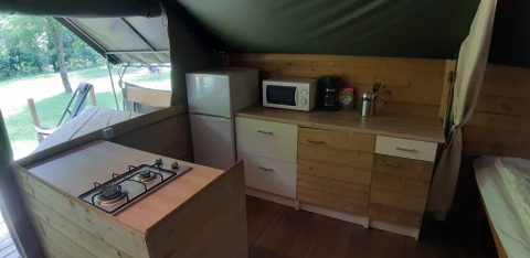Køkkenområde i Kibo safari-telt på Ushuaïa Villages Le Viaduc campingplads med komfur og hvidevarer.