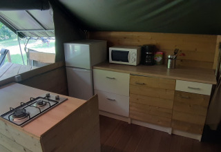 Angolo cucina nella tenda safari Kibo al campeggio Ushuaïa Villages Le Viaduc con fornelli e frigorifero.