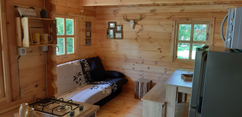 Cozy wooden interior of Ranch Chalet at Campsite Ushuaïa Villages Le Viaduc, featuring sofa and dining area.