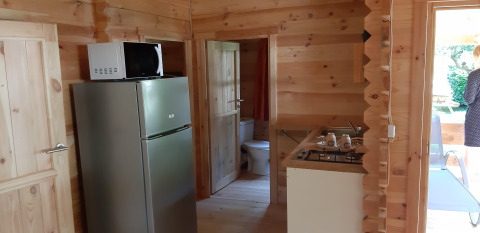 Innenraum des Ranch Chalets in Ushuaïa Villages Le Viaduc mit Küche, Kühlschrank und Holzwänden.