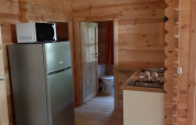 Intérieur du Ranch Chalet à Ushuaïa Villages Le Viaduc avec cuisine, réfrigérateur, micro-ondes et murs en bois.