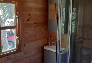 Bathroom in Ranch Chalet at Ushuaïa Villages Le Viaduc, featuring a window, small sink, and shower.