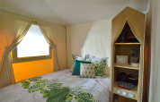Sleeping area in the 'Jungle Lodge' safari tent at Campsite Ushuaïa Villages Le Viaduc, France, with leafy decor.