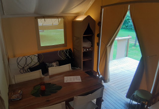 Interior view of Jungle Lodge safari tent at Campsite Ushuaïa Villages Le Viaduc in France, showing dining area.
