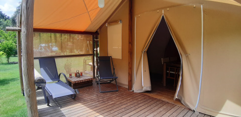 Safari tent Jungle Lodge at Ushuaïa Villages Le Viaduc campsite in France with deck and lounge chairs.