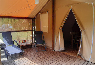 Safari tent Jungle Lodge at Ushuaïa Villages Le Viaduc campsite in France with deck and lounge chairs.