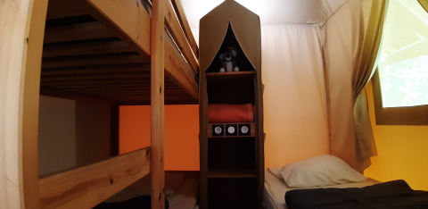 Interieur van het Jungle Lodge safaritent op Camping Ushuaïa Villages Le Viaduc, met stapelbed en bed.