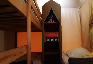 Interieur van het Jungle Lodge safaritent op Camping Ushuaïa Villages Le Viaduc, met stapelbed en bed.