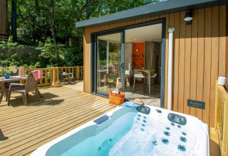 Outdoor deck with hot tub and dining set at Campsite «Le Luberon» holiday park in Provence-Alpes-Côte d’Azur, France.