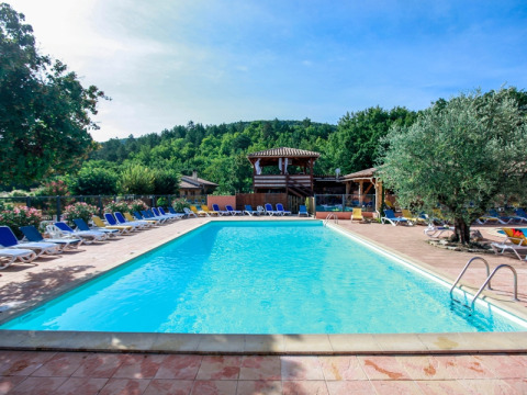 Outdoor swimming pool with sun loungers and trees at Campsite Le Luberon in Provence-Alpes-Côte d’Azur, France.