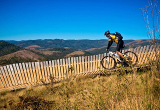 Un cycliste roule sur un sentier de montagne près d’Apt, Provence-Alpes-Côte d’Azur, France, sous un ciel bleu.
