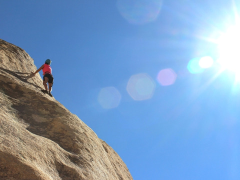 Personne escaladant une falaise sous le soleil au camping Le Luberon en Provence-Alpes-Côte d’Azur, France.