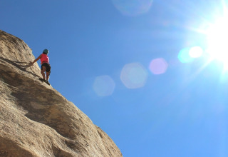 Personne escaladant une falaise sous le soleil au camping Le Luberon en Provence-Alpes-Côte d’Azur, France.