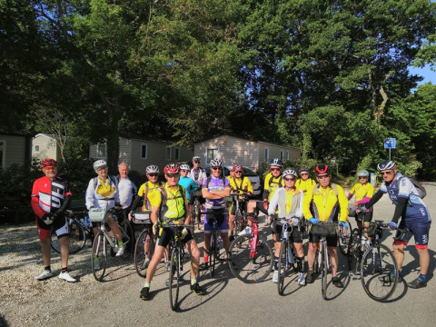 Un groupe de cyclistes pose avec leurs vélos sous les arbres au camping Le Luberon, en Provence, France.