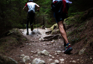 Deux personnes courent sur un sentier rocailleux à travers la forêt du camping «Le Luberon» en Provence.
