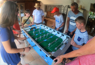 Groupe de personnes jouant au baby-foot au camping Le Luberon, un parc de vacances en Provence-Alpes-Côte d’Azur, France.