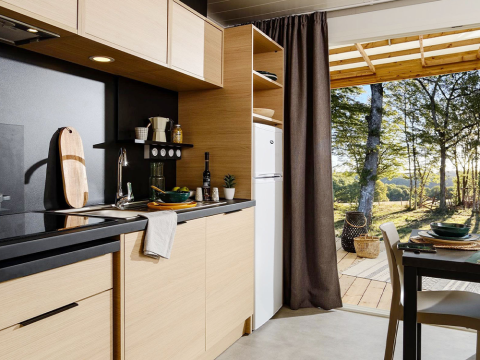 Modern kitchen in Lodge at Campsite La Nouvelle Croze, France, with view to the forest and nature.