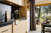 Modern kitchen in Lodge at Campsite La Nouvelle Croze, France, with view to the forest and nature.