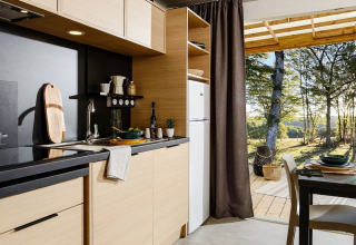 Cucina moderna nella lodge al campeggio La Nouvelle Croze in Francia, con vista sulla natura e bosco.