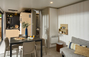 Modern lodge interior at Campsite La Nouvelle Croze in France featuring a dining area and kitchenette.