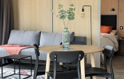 Modern lodge interior with dining table, sofa, and visible bedroom at La Nouvelle Croze Campsite in France.