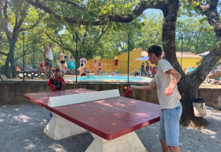 Due persone giocano a ping pong all'aperto vicino a una piscina al Domaine des Chênes Blancs, Provenza, Francia.