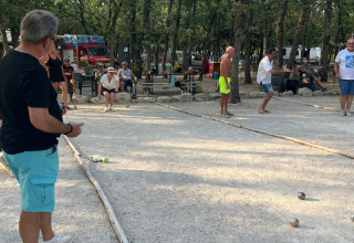 Menschen spielen Pétanque auf einem Platz im Domaine des Chênes Blancs, Ferienpark in Provence-Alpes-Côte d’Azur.