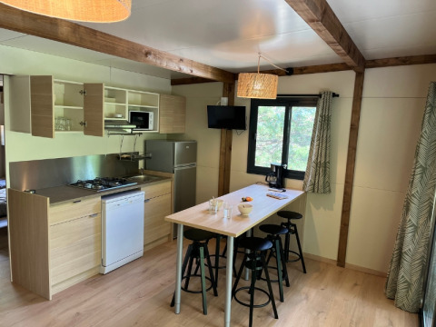 Angolo cottura moderno e zona pranzo al Cottage «Pantaïa» presso il campeggio Le Luberon in Francia.