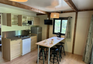 Angolo cottura moderno e zona pranzo al Cottage «Pantaïa» presso il campeggio Le Luberon in Francia.