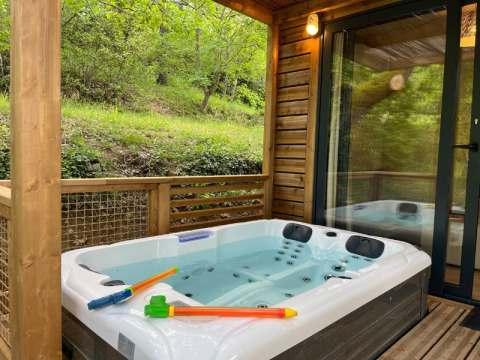 Vasca idromassaggio esterna su terrazza in legno al Cottage «Pantaïa», Campeggio Le Luberon, tra il verde.