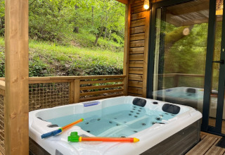 Vasca idromassaggio esterna su terrazza in legno al Cottage «Pantaïa», Campeggio Le Luberon, tra il verde.
