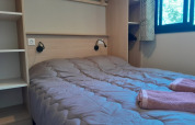 Camera da letto nella casa sull'albero Cottage «Séouvo» con letto matrimoniale e asciugamani a Le Luberon.