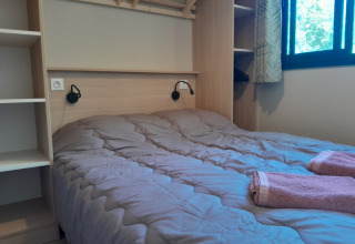 Camera da letto nella casa sull'albero Cottage «Séouvo» con letto matrimoniale e asciugamani a Le Luberon.