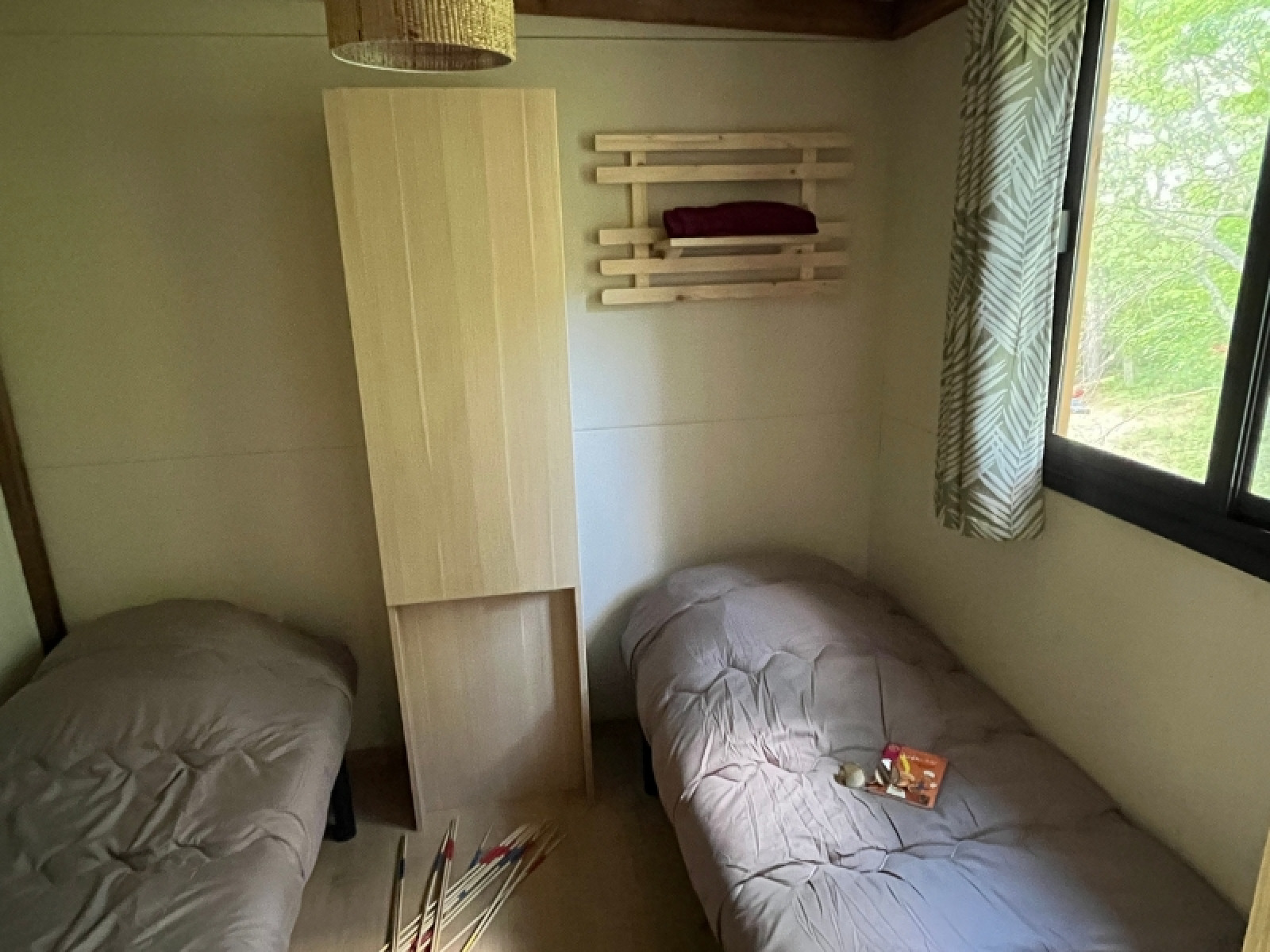 Kamer in Cottage Séouvo op Camping Le Luberon in Frankrijk met twee bedden, een kast en een raam.