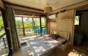 Vista interna della casa sull’albero Cottage «Séouvo» al Campeggio Le Luberon, letto e terrazzo.