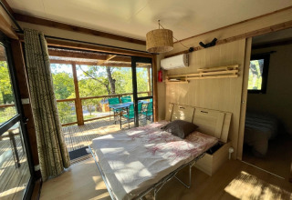 Vista interna della casa sull’albero Cottage «Séouvo» al Campeggio Le Luberon, letto e terrazzo.