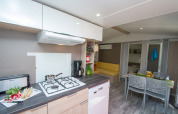 Modern kitchen and living area in Cottage Romarin at Campsite Le Luberon, France, featuring dining space.