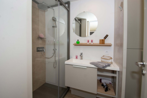 Bagno moderno nel Cottage Evasion presso il Campeggio Le Luberon, Francia, con doccia e lavandino.