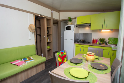 Interno moderno del Cottage Lavande al Campeggio Le Luberon in Francia, con cucina e sala da pranzo.
