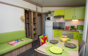 Bright kitchen and dining area in Cottage Lavande at Campsite Le Luberon in France, with green accents.