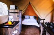 Premium lodge safari tent with kitchen and double bed at Domaine des Chênes Blancs, France, interior view.