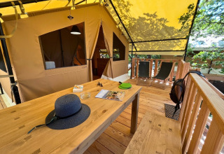 Terrasse en bois d'une tente safari « Bungalowtent » au Domaine des Chênes Blancs en France, chez des arbres.