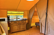 Binnenzijde van de Bungalowtent safaritent bij Domaine des Chênes Blancs in Frankrijk, met eenvoudig keukentje.