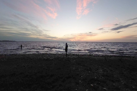 Solnedgang over havet set fra stranden ved 4 personers feriehus i Haderslev, Danmark, med silhuetter.