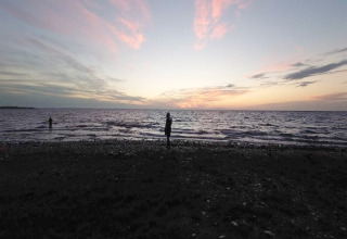 Sonnenuntergang über dem Meer am Strand beim 4-Personen-Ferienhaus in Haderslev, Dänemark, mit Silhouetten.