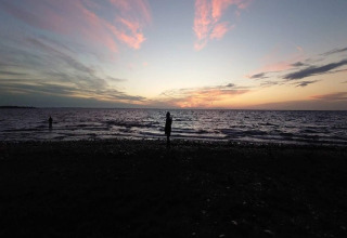 Coucher de soleil sur la mer, vu depuis la plage du logement 4 personnes à Haderslev, Danemark, avec des silhouettes.