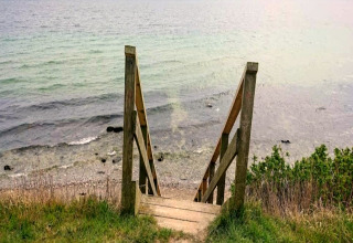 Holztreppe führt zum Strand am Wasser, fotografiert bei einem 4-Personen-Ferienhaus in Haderslev.
