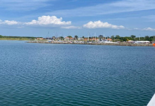 Vue sur l’eau vers un port de plaisance et des maisons à Haderslev, Danemark, sous ciel bleu et nuages.