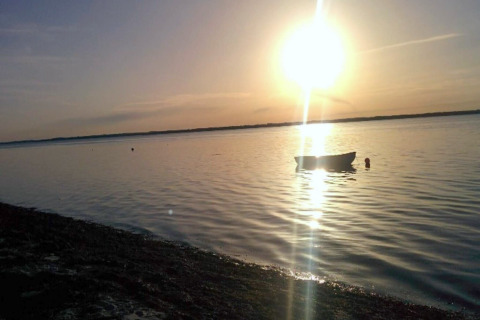 Tramonto sull'acqua al «casa vacanze per 4 persone a Haderslev», Danimarca, con una barca visibile.